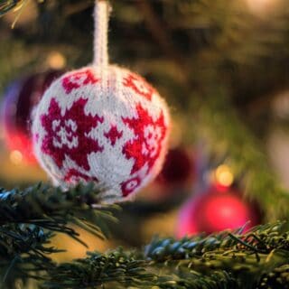 white and red knit bauble on green Christmas tree